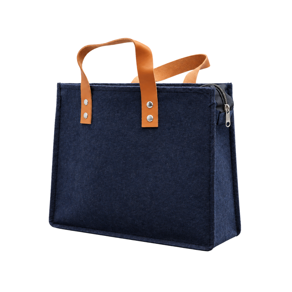 A navy blue felt tote bag with tan leather handles and a zippered top, isolated on a white background.