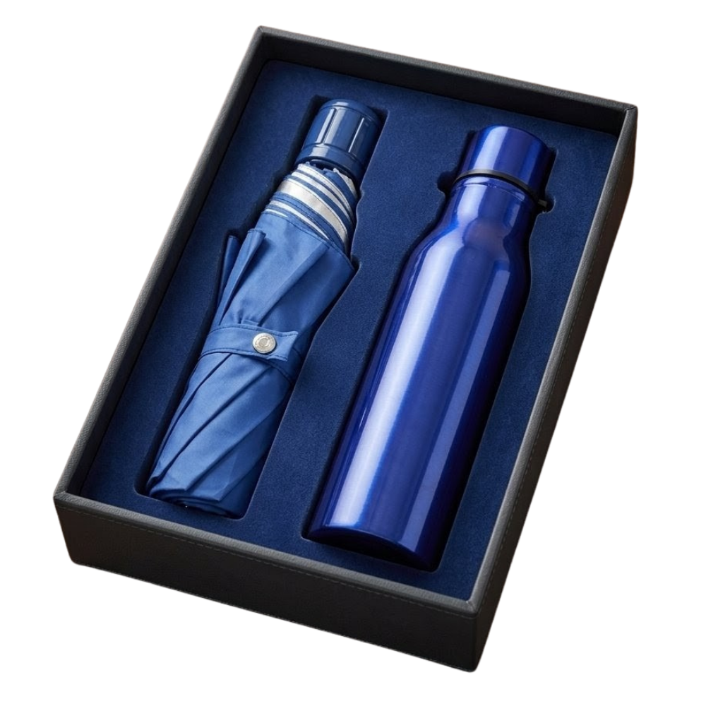 A navy blue vacuum-insulated bottle and a matching compact travel umbrella displayed inside a black presentation gift box with blue velvet lining.