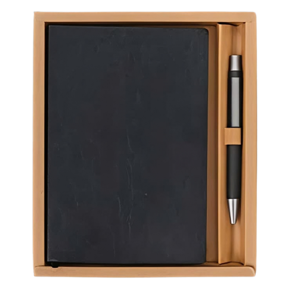 Top-down view of a charcoal notebook and matching pen inside a tan gift box.