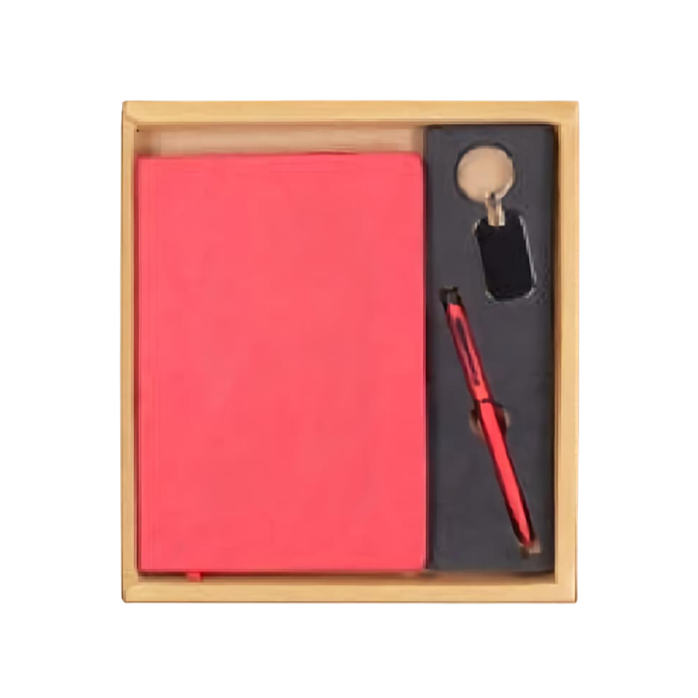 Top-down view of a rose gold stationery gift set inside a wooden box, including a notebook, pen, and keychain.