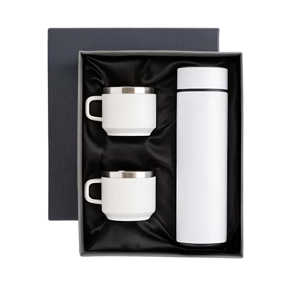 A white vacuum insulated bottle and two matching mugs inside a black satin-lined gift box.