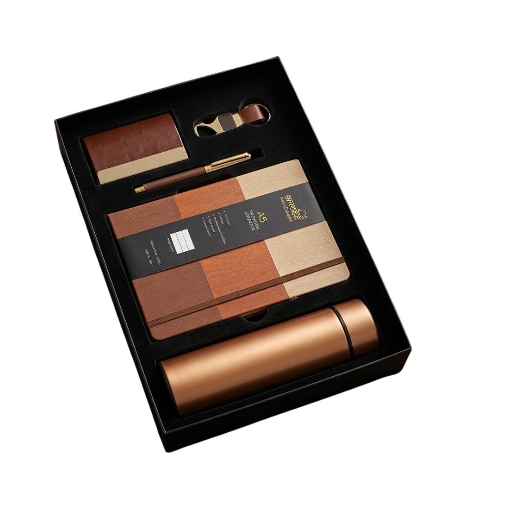 A premium executive gift set in a black box containing a rose gold bottle, notebook, pen, and card holder.