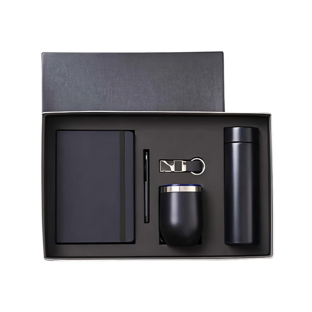 Top-down view of an executive gift set in a black box, containing a notebook, pen, keychain, tumbler, and bottle.