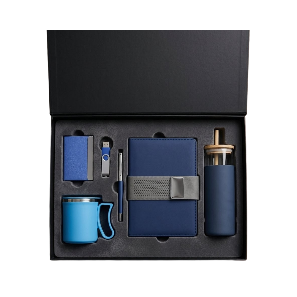 A professional executive gift set in a black box containing a blue notebook, pen, USB drive, card holder, mug, and glass bottle.