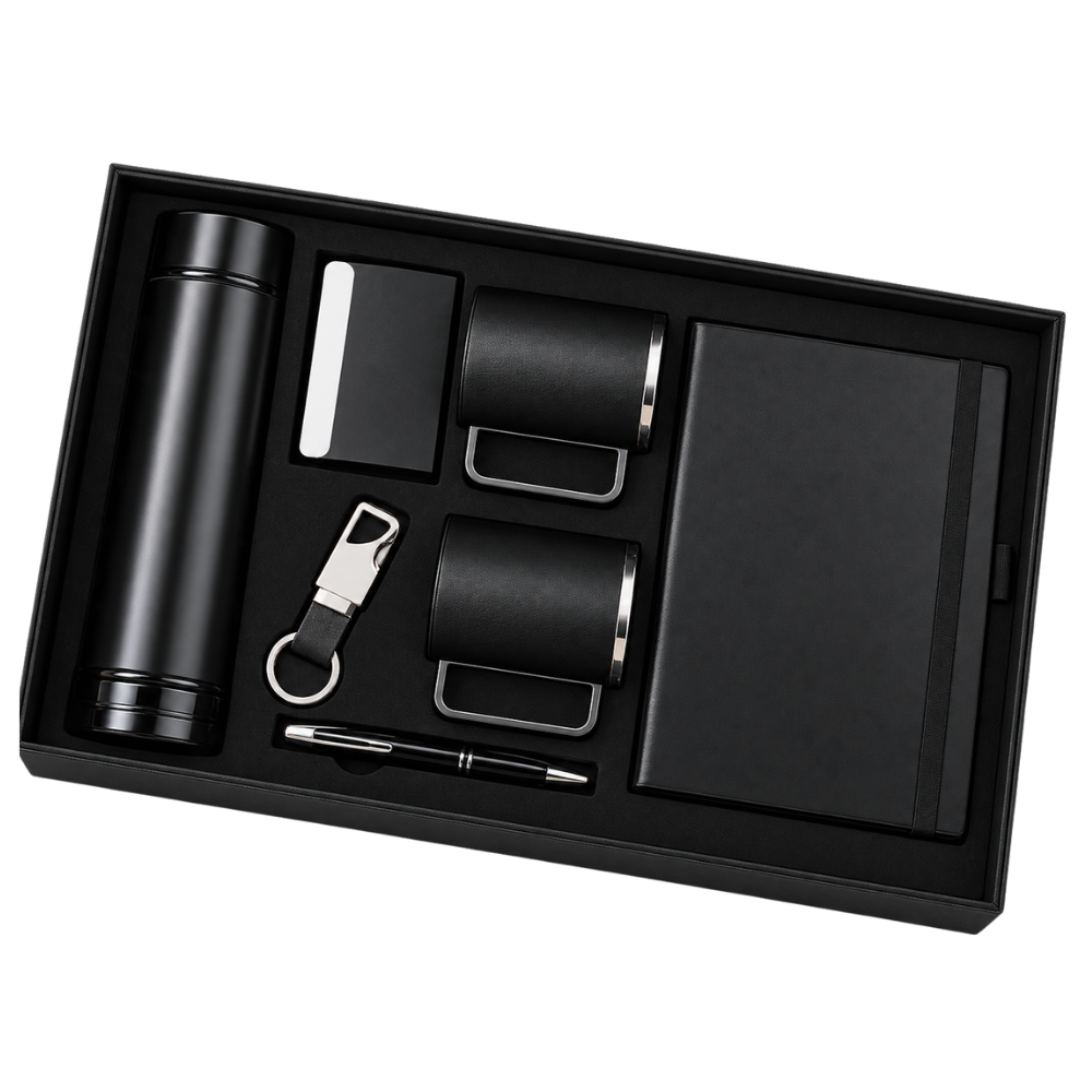 A top-down view of a 6-piece executive gift set in a black box, including a vacuum bottle, two mugs, a notebook, a pen, and a keychain.